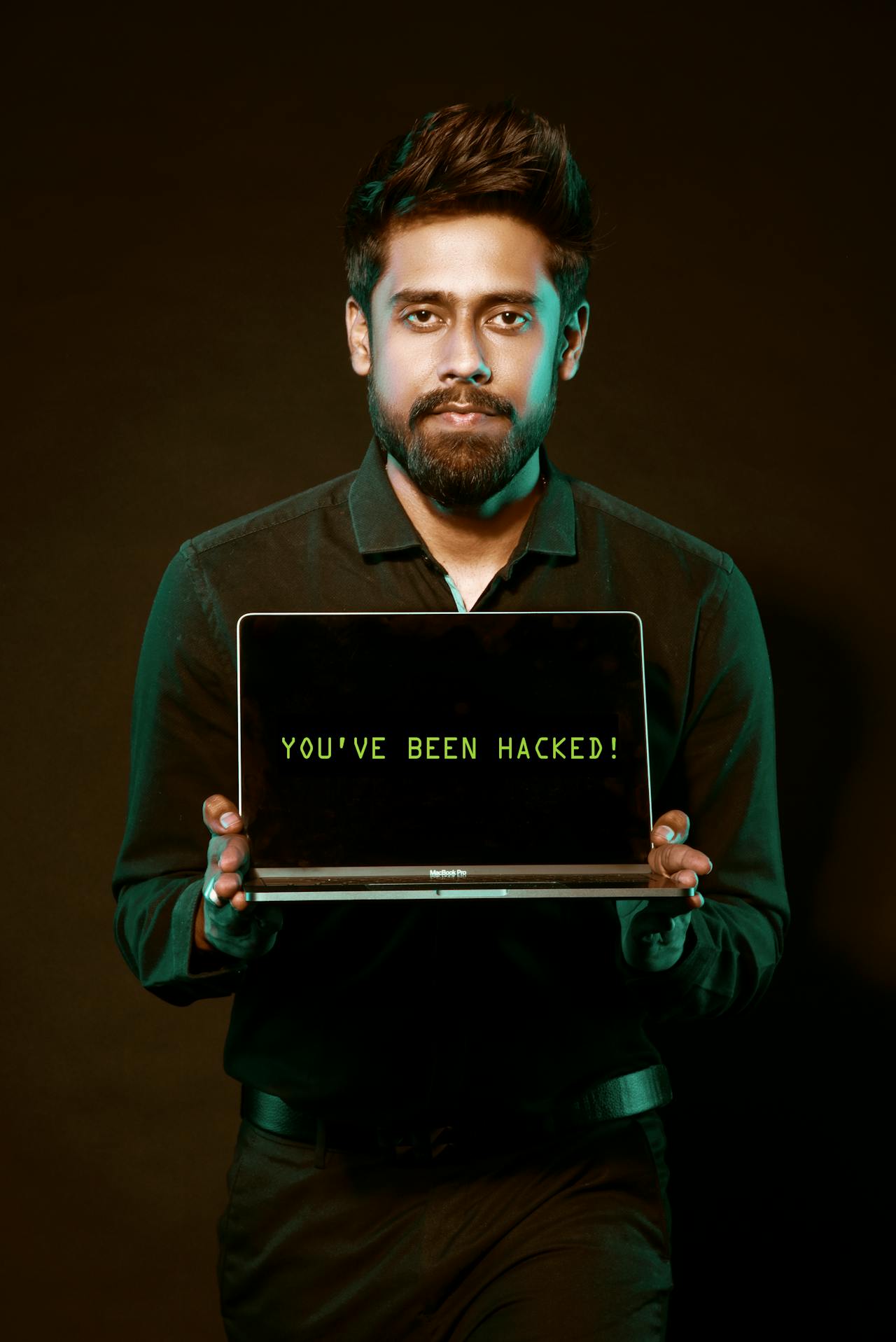 A person holding a laptop with a security warning on screen