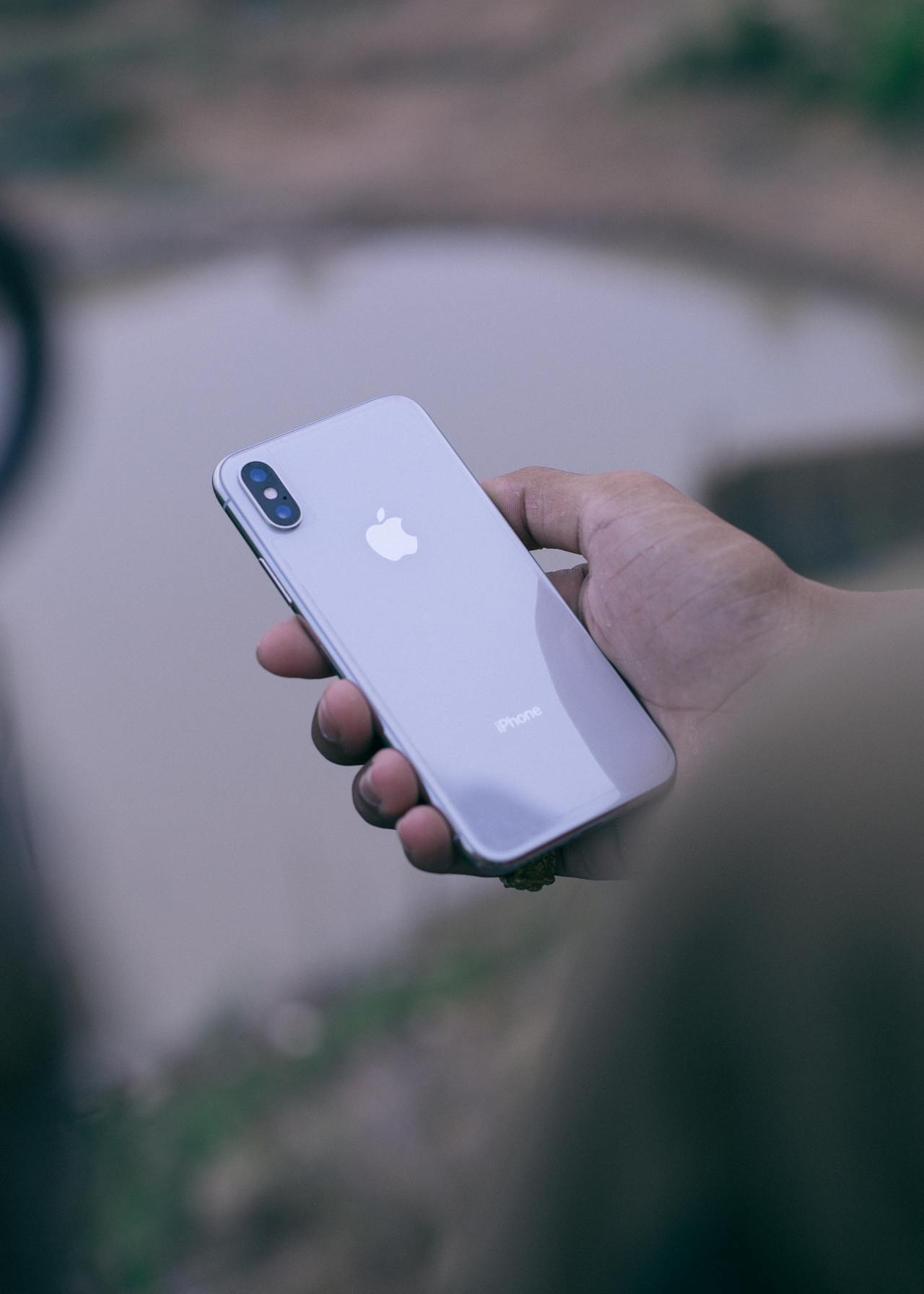 A smartphone held in one hand against a soft background